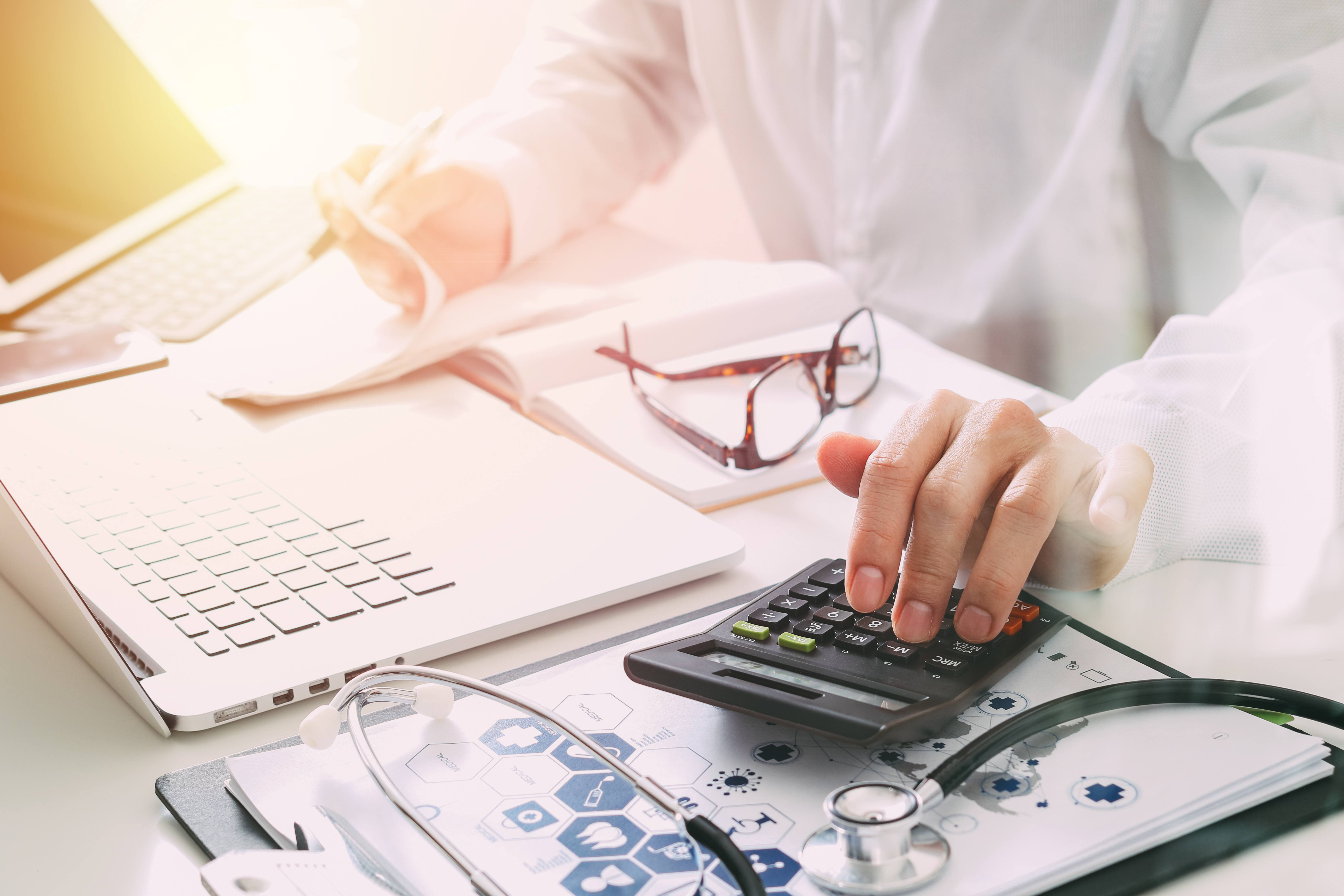 A doctor sitting at their desk and determining that it is time to outsource medical billing.